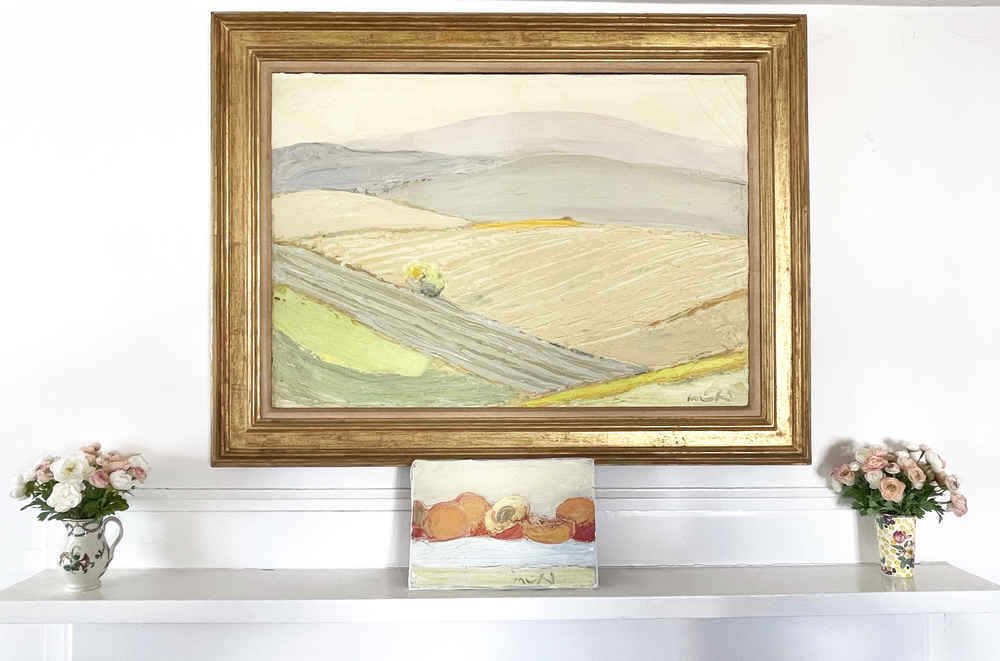 A large painting hanging on the wall with a small painting of peaches below it on the mantel