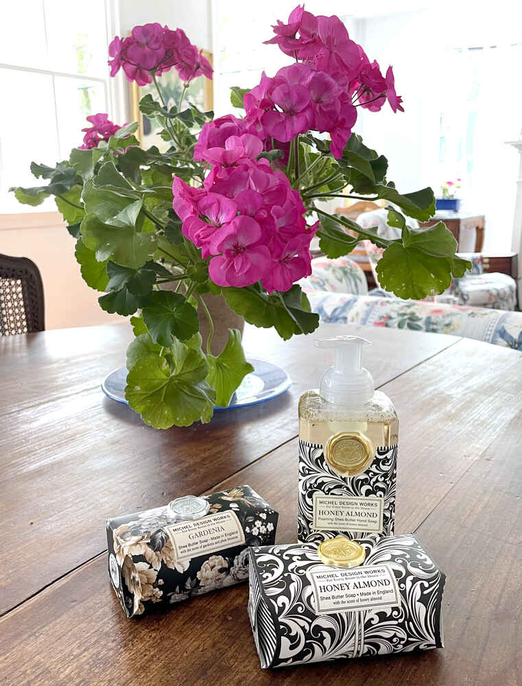 Three soaps in front of pink geraniums