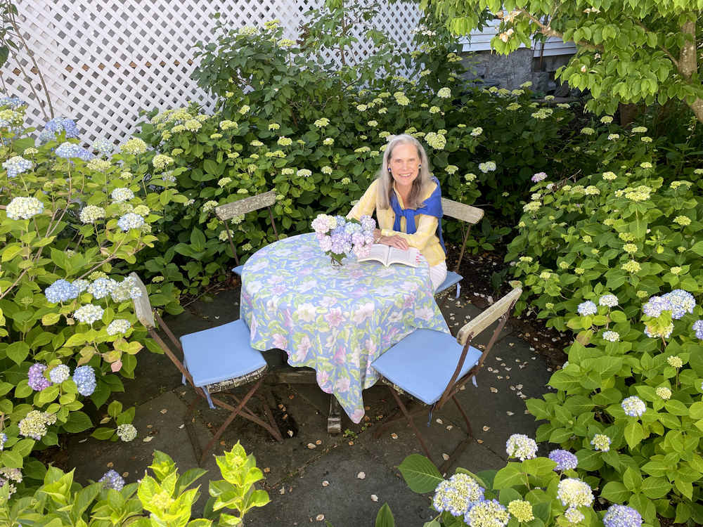 Alexandra at a table surrounded by hydrangea