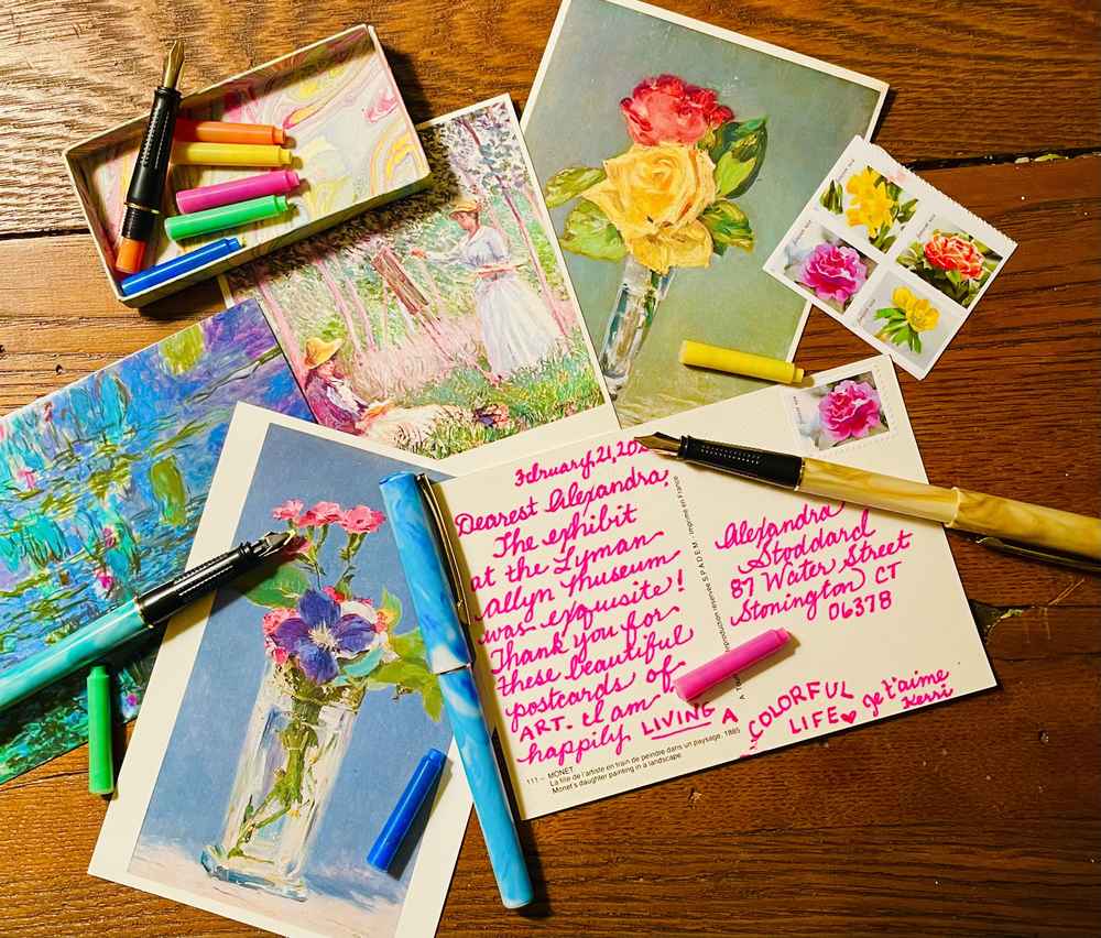 Brightly colored postcards and pens on a brown wooden desk
